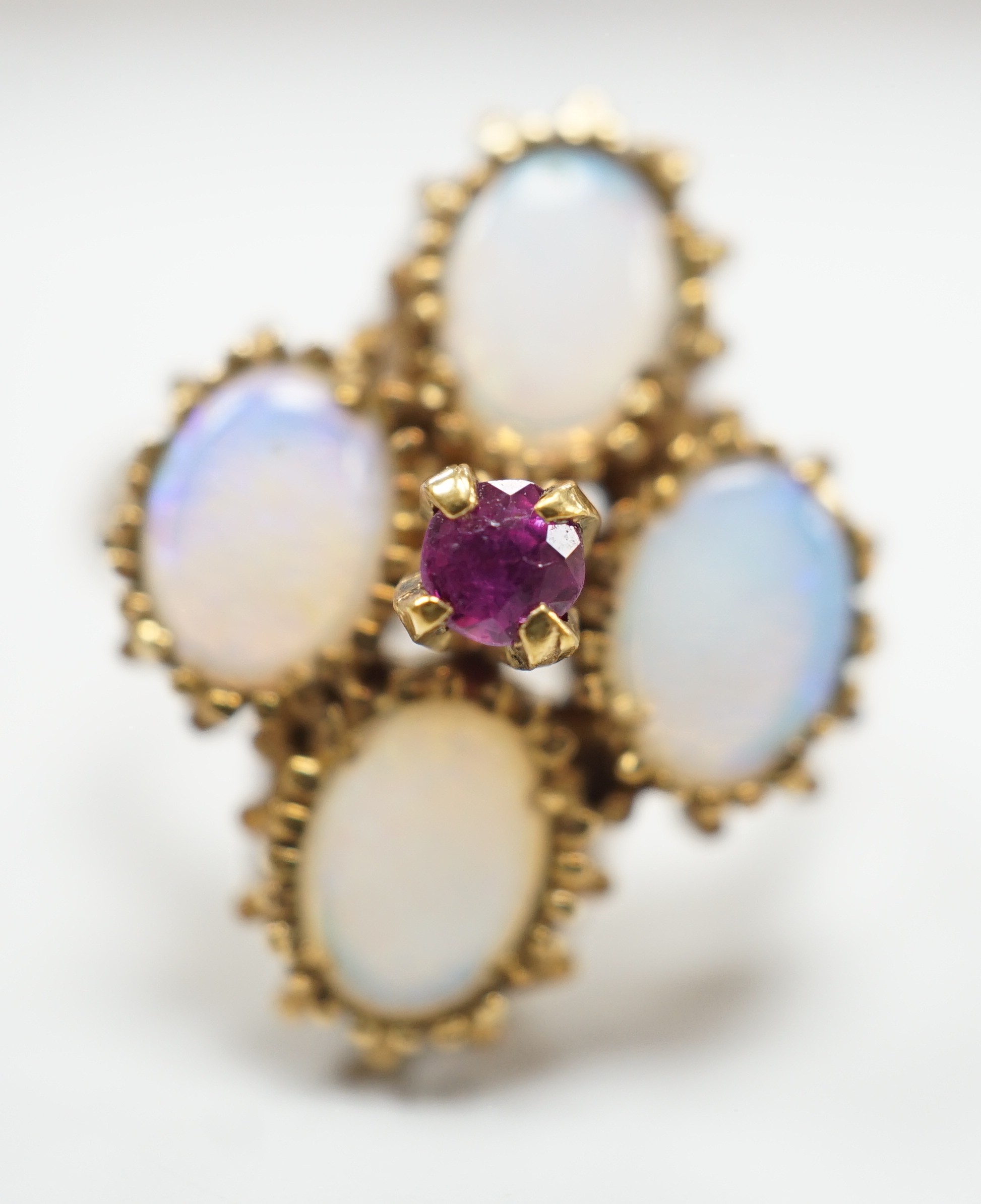A 1970's 9ct gold, four stone white opal and single stone ruby cluster set dress ring, size O, gross weight 5.2 grams.